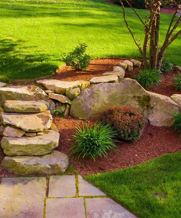 A landscaped stone walkway surrounded by grass and shrubs in North Dallas and surrounding areas.